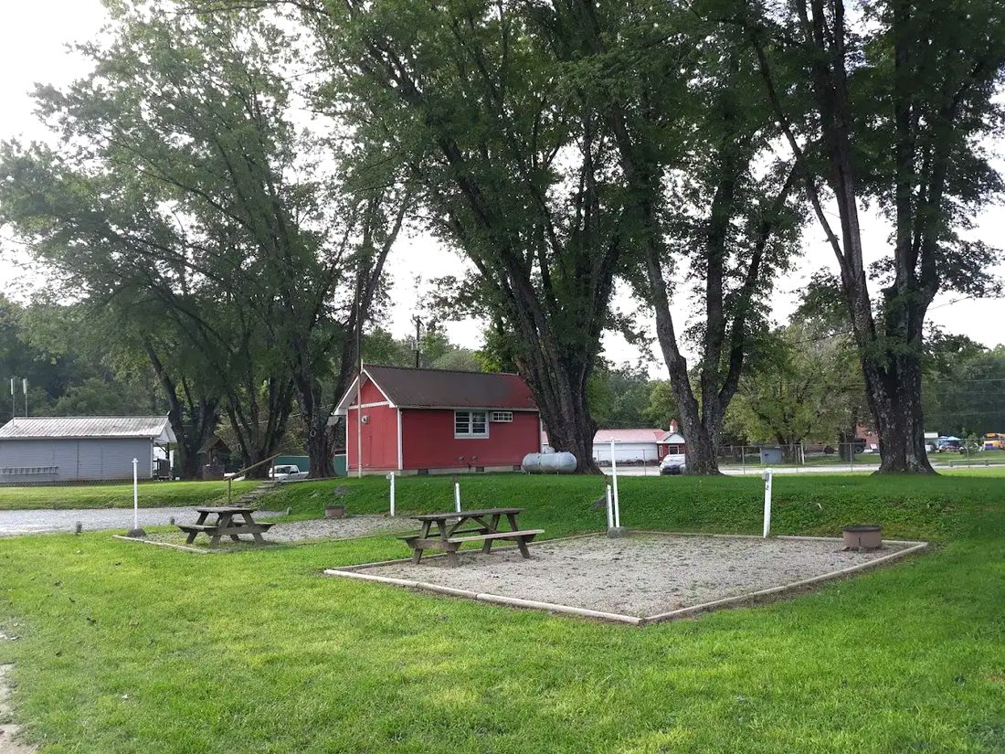 Open grassy area with picnic tables and shade trees at Riverbreeze