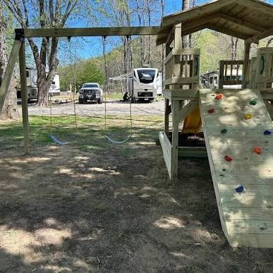 The playground climbing wall with RVs parked behind