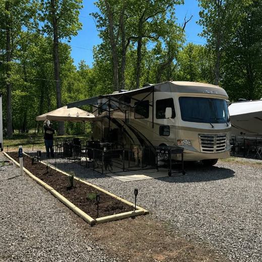 A motorhome parked on a level gravel site with an awning and patio