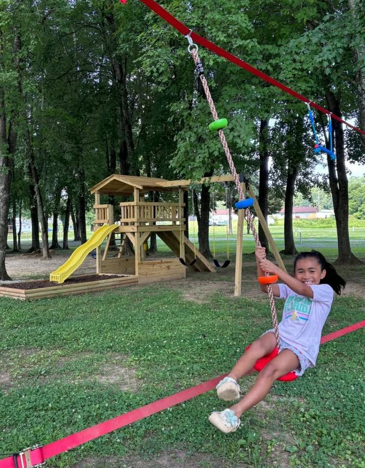 A child riding the zip line at the playground