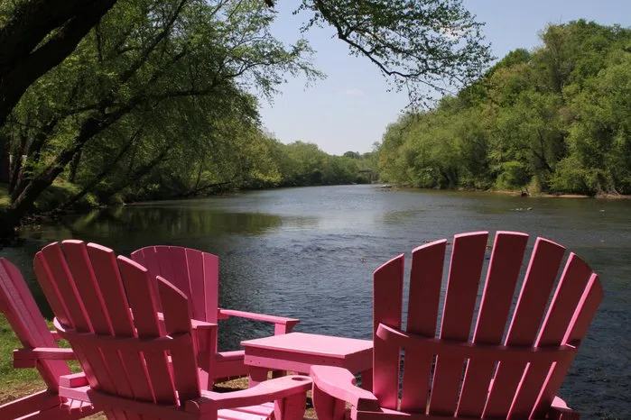 Red Adirondack chairs and a picnic table looking out over the Catawba River