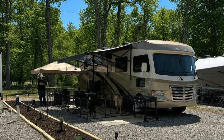 Motorhome parked on a level gravel site with an awning and patio